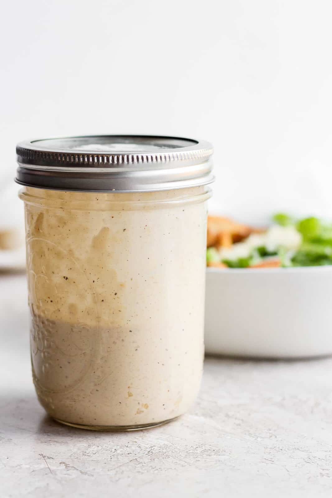 Mason jar with homemade caesar dressing in it.