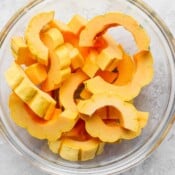 Slices of delicata squash in a glass bowl.