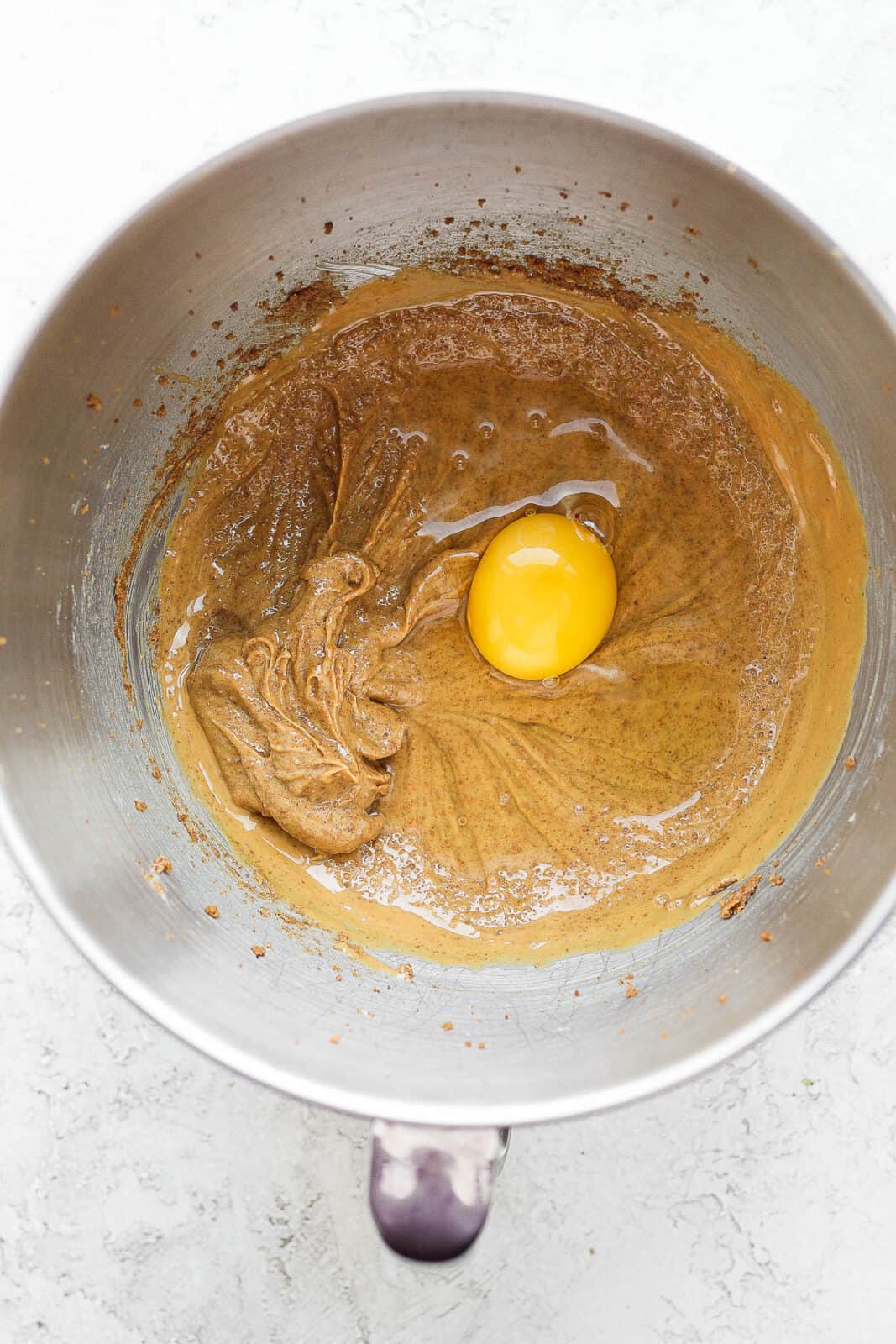 Egg, peanut butter and coconut sugar mixed together in a bowl with egg on top.
