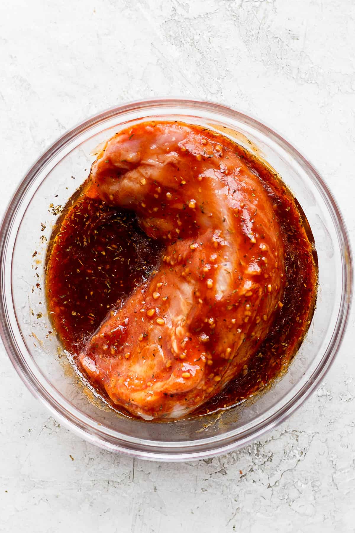 A pork loin sitting in a homemade marinade.