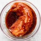 Pork loin with the pork loin marinade in a glass bowl.