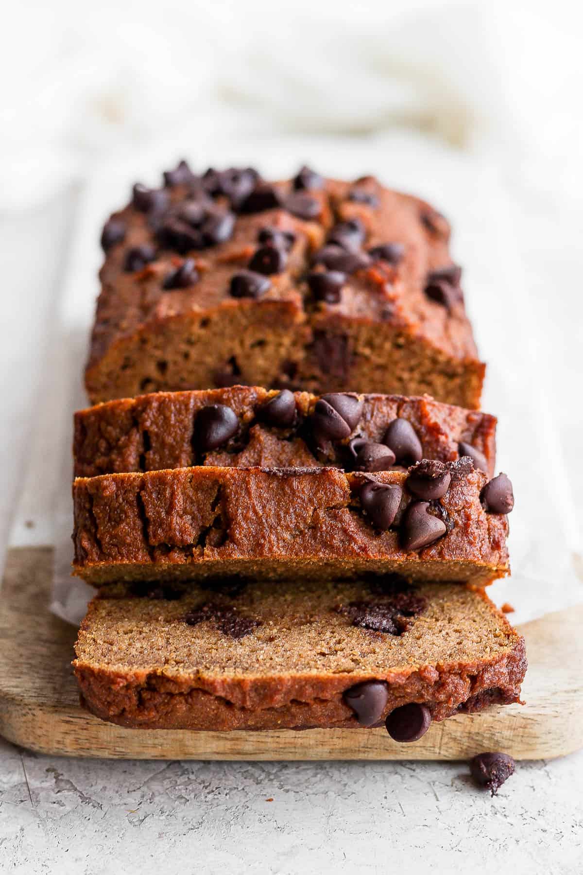 Sliced pumpkin bread on a cutting board.