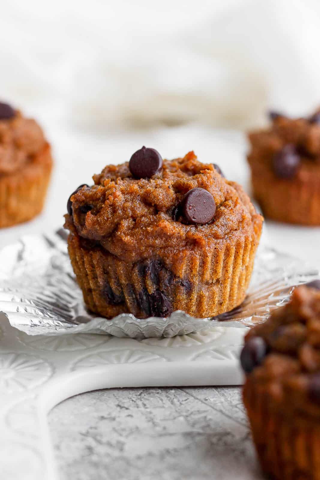 A pumpkin muffin with the wrapper pulled down.