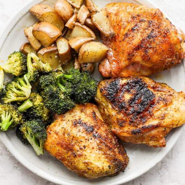 Plate of smoked chicken thighs, broccoli and potatoes.