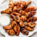 Plate of smoked chicken wings with a little bowl of ranch dressing on plate.