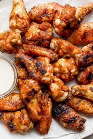 Plate of smoked chicken wings with a little bowl of ranch dressing on plate.