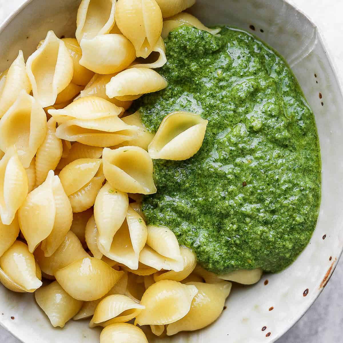 Bowl of vegan pesto with cooked shells.