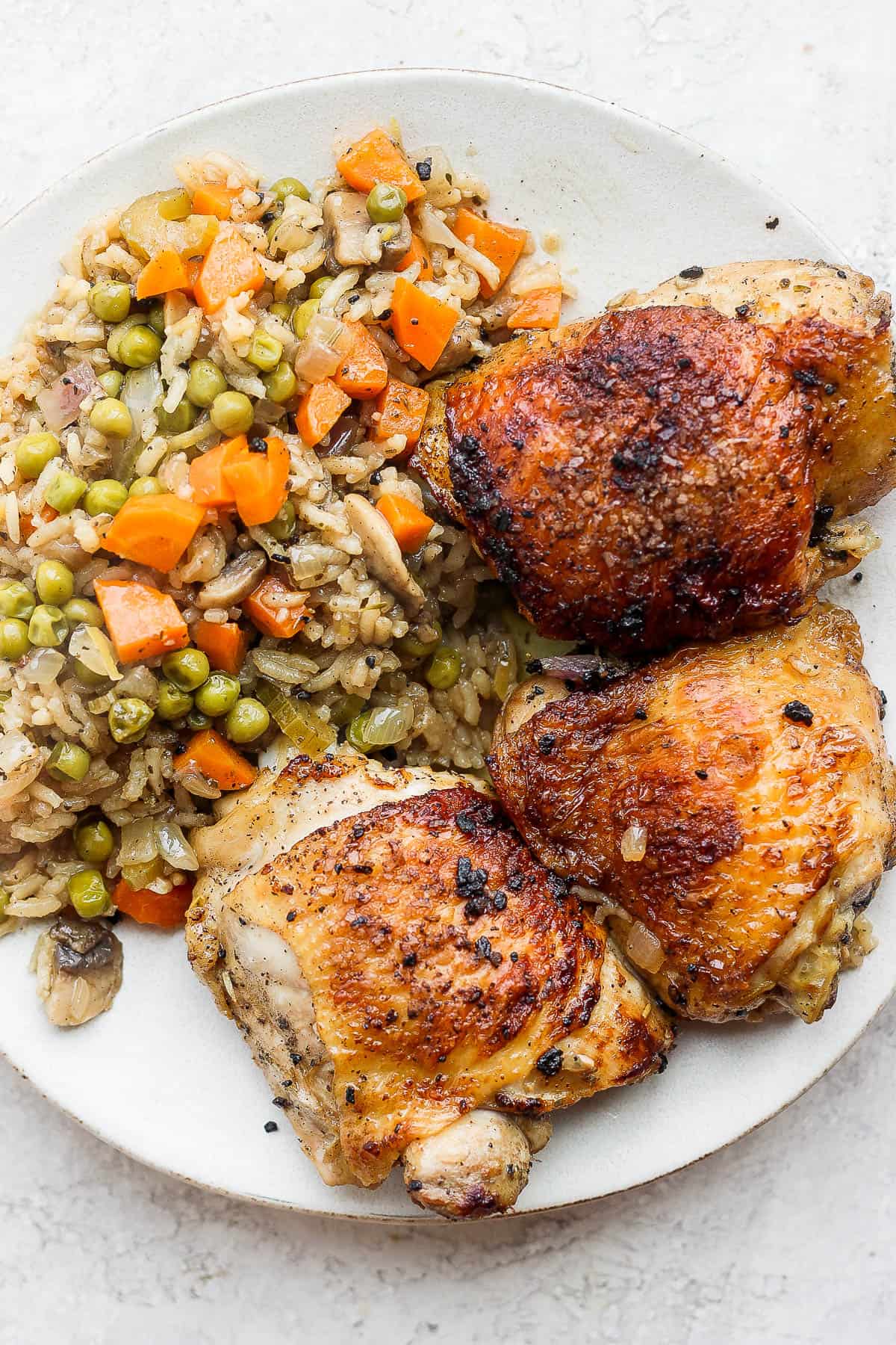 Baked chicken and rice on a plate.