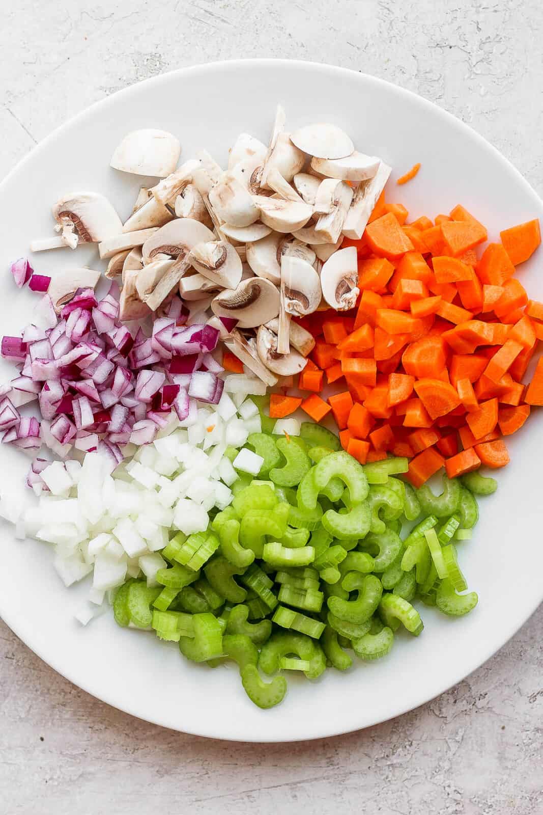Cut up vegetables on a plate for shepherd's pie.