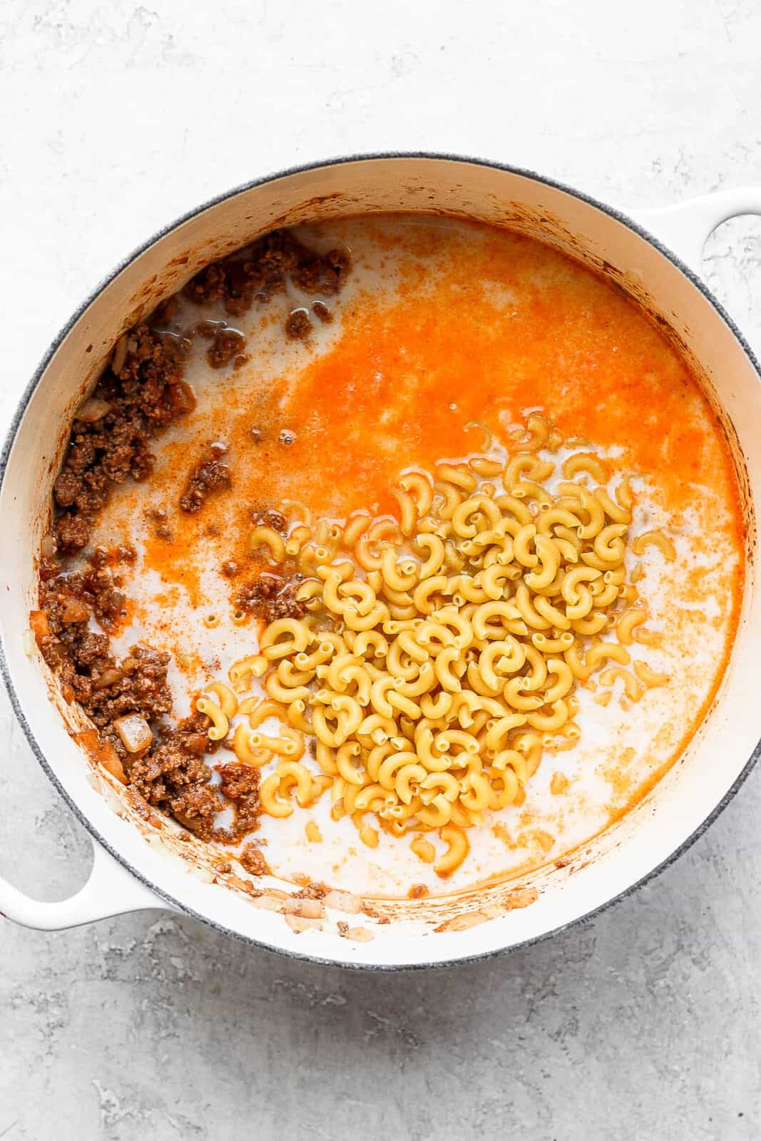 Macaroni noodles being added to the pot.