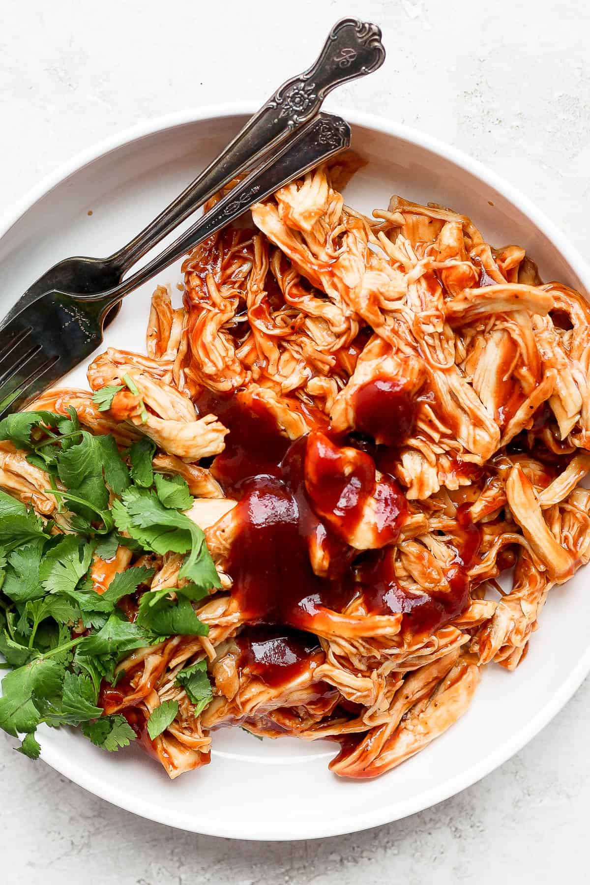 A bowl of bbq chicken with cilantro. 