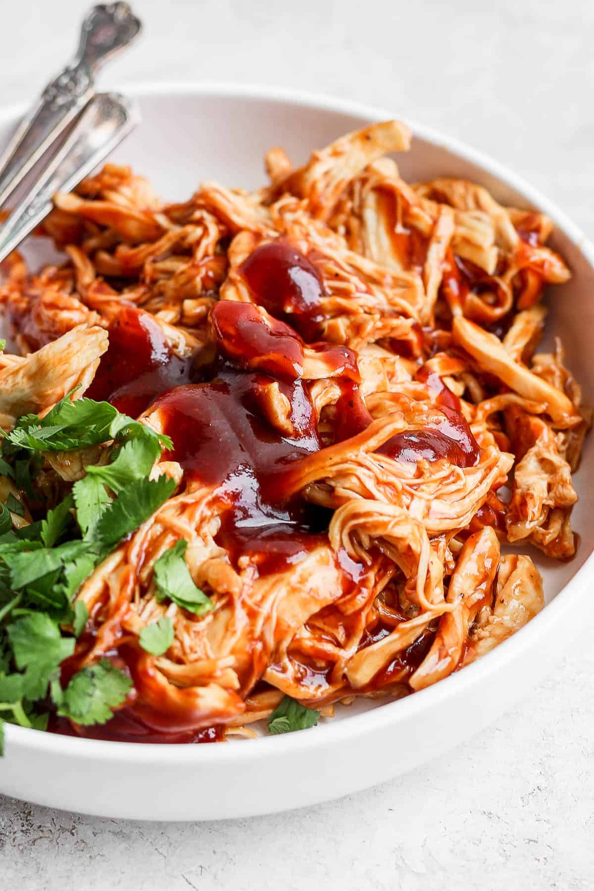 Instant Pot BBQ chicken on a plate with cilantro.