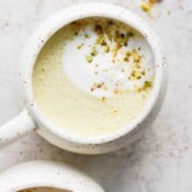 Mug full of a pistachio latte.