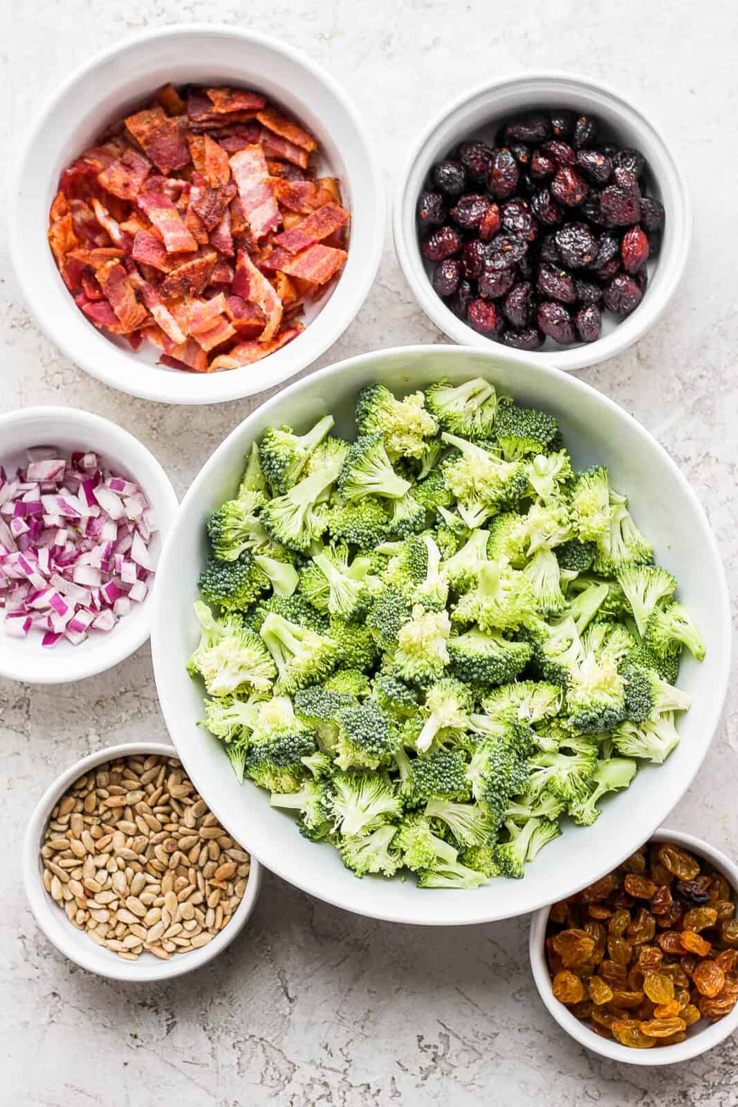 Ingredients for broccoli bacon salad in small dishes.