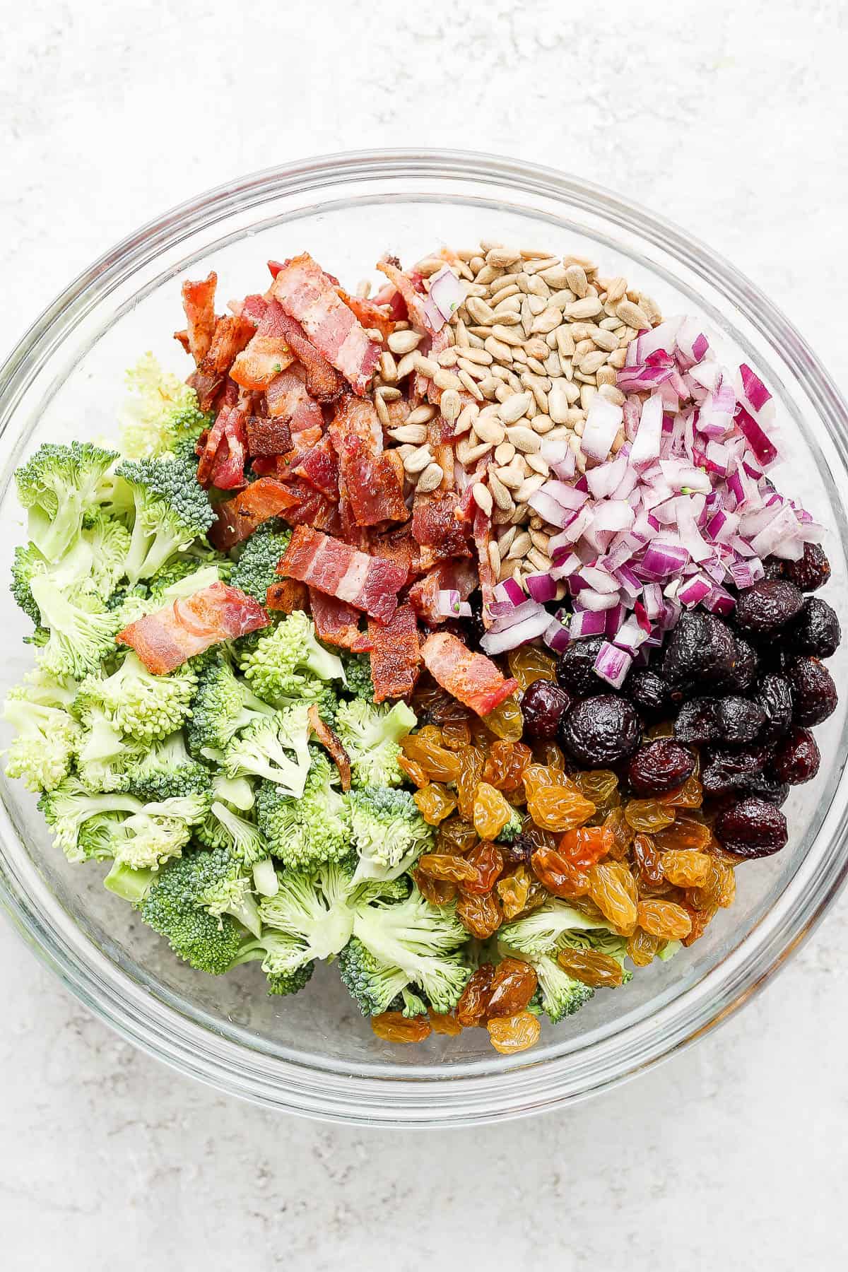 Ingredients for broccoli bacon salad in a large mixing bowl.