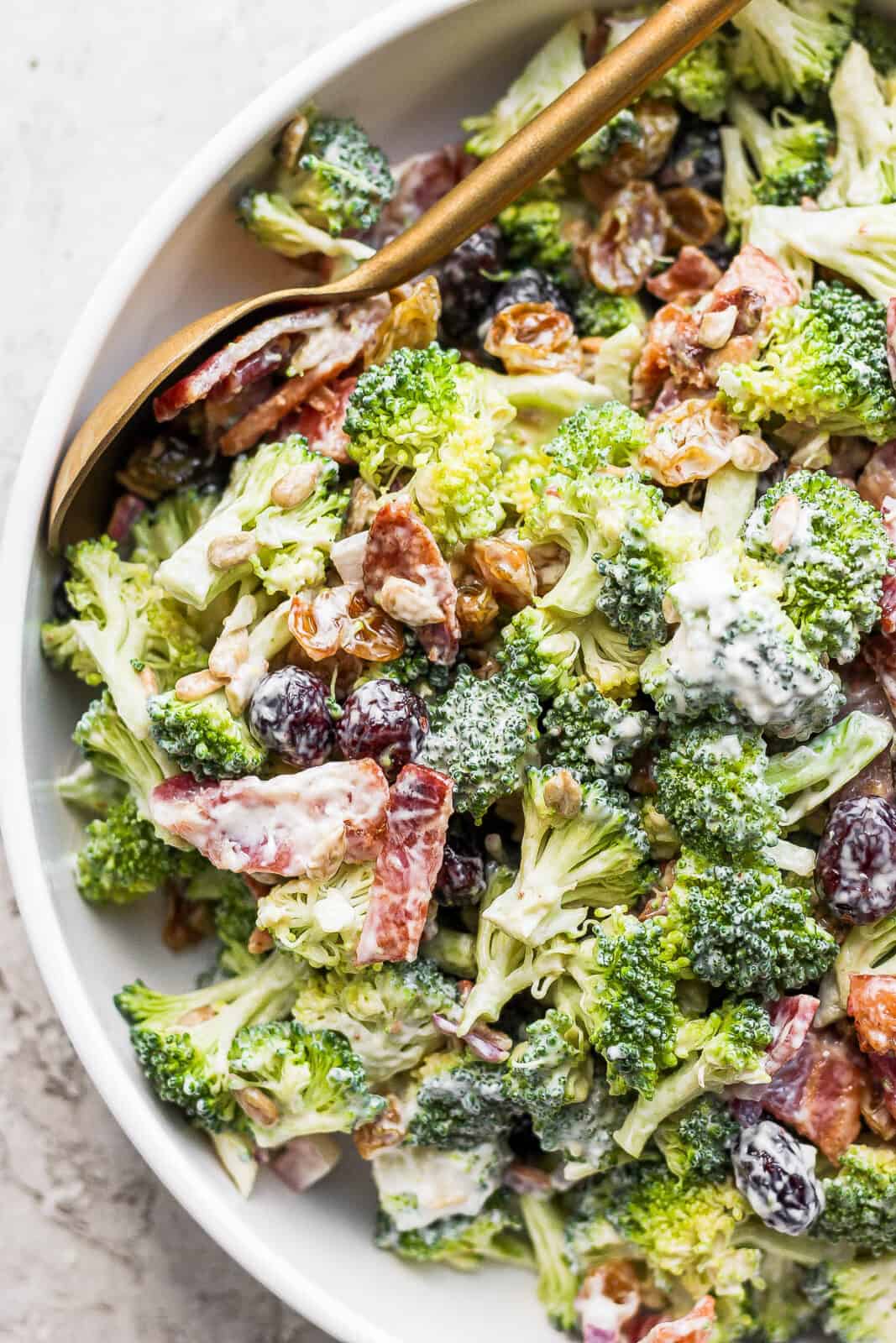Broccoli bacon salad in a bowl with a spoon.