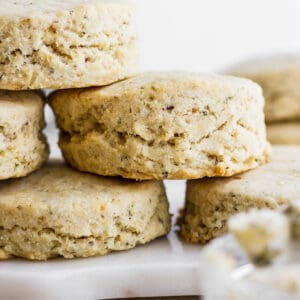 Several gluten free herby biscuits stacked on top of each other.