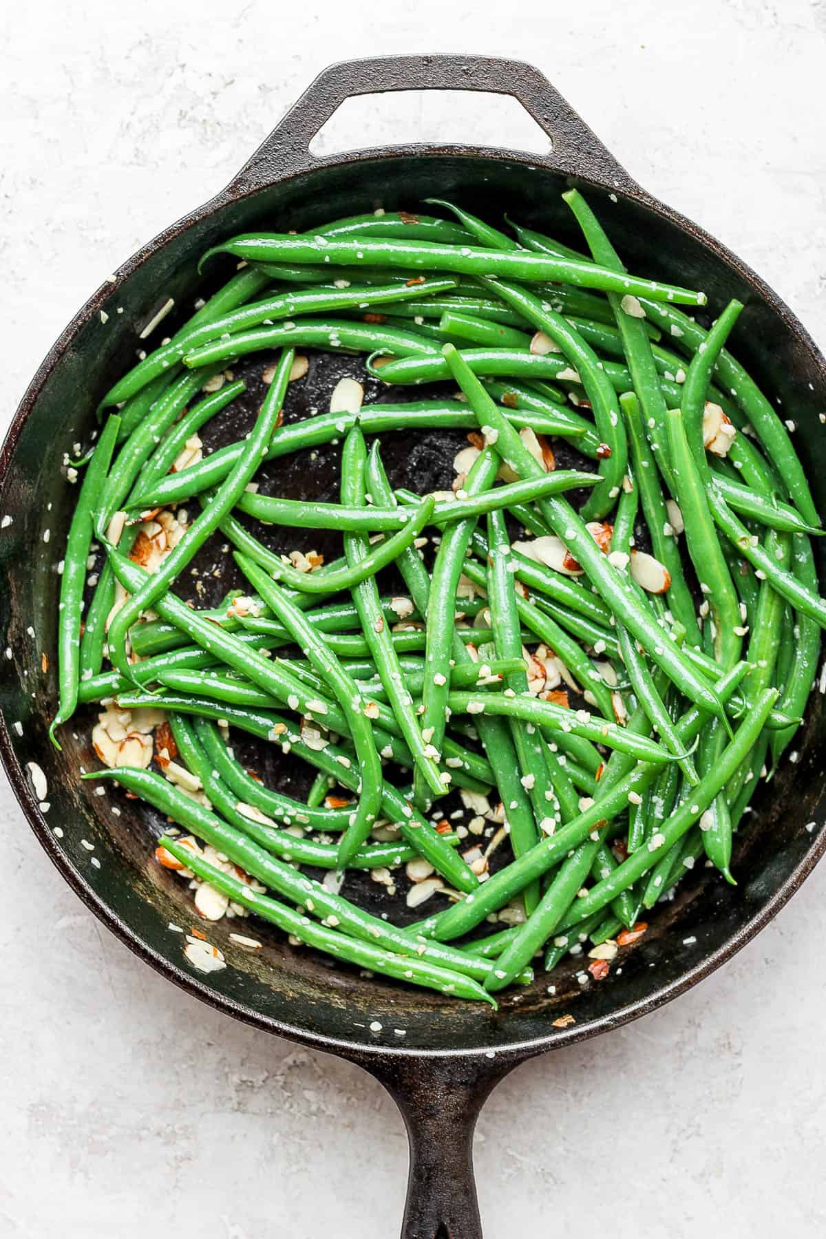 Green bean almondine in a cast iron skillet.