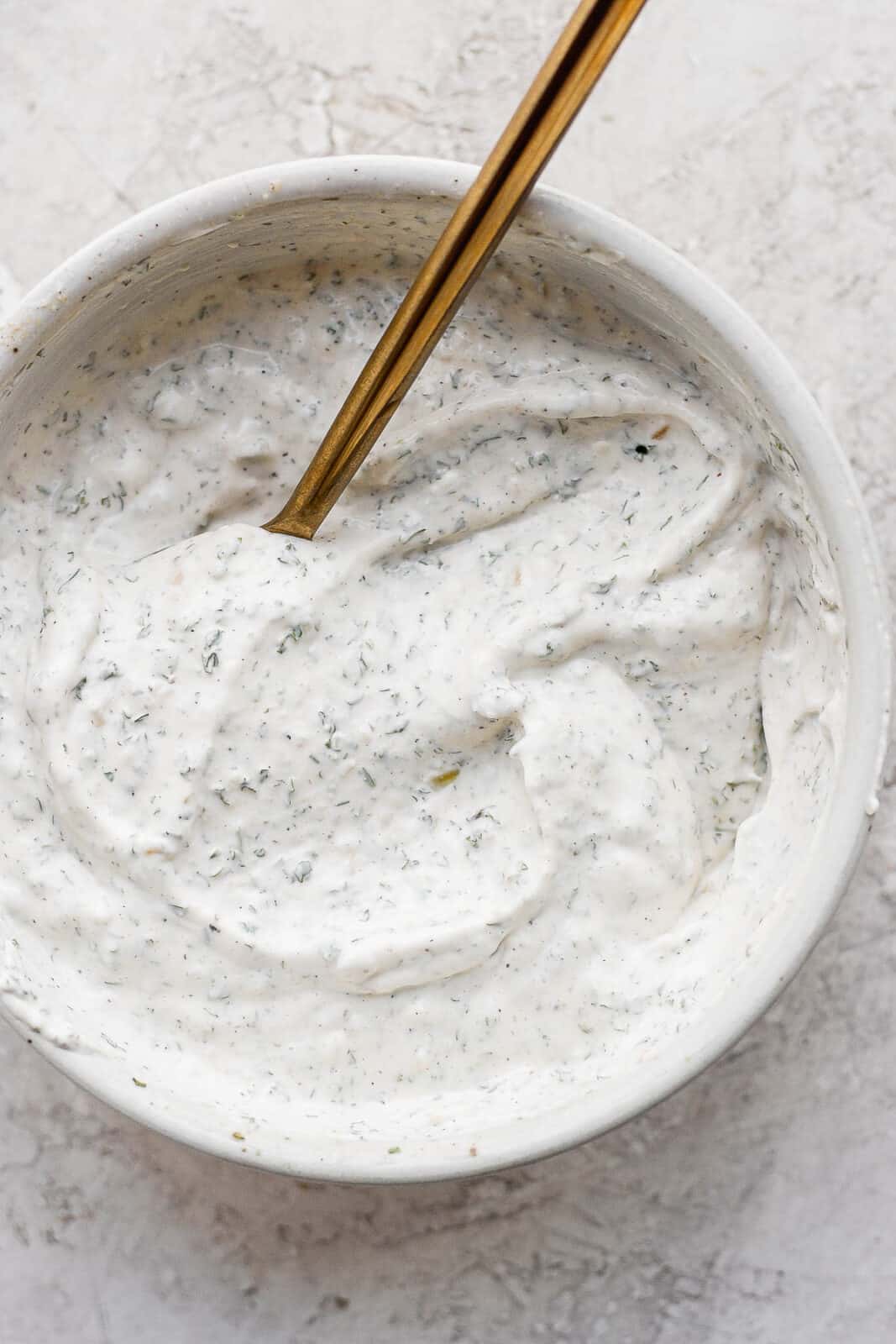 A bowl of healthy veggie dip with a spoon.