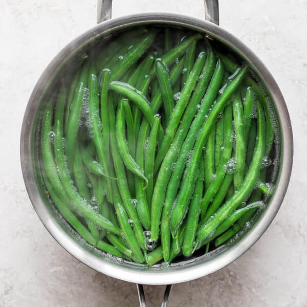 Saucepan full of blanched green beans.