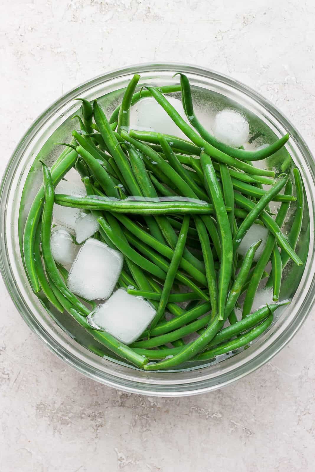 Blanched green beans in an ice bath.