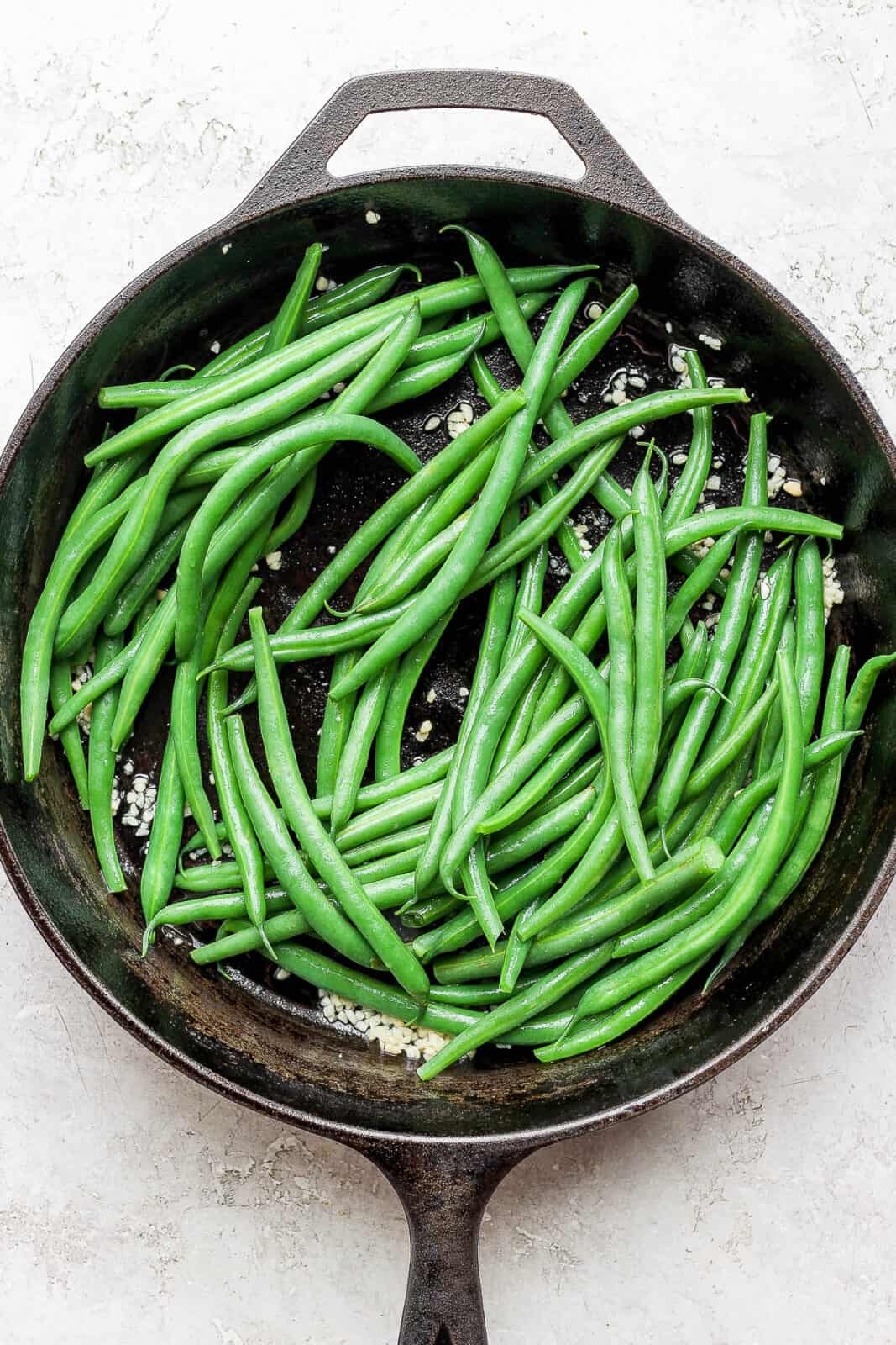 Blanched green beans in a cast iron skillet.
