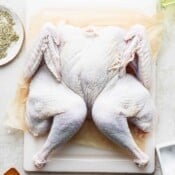 A spatchcock turkey on a piece of parchment paper.
