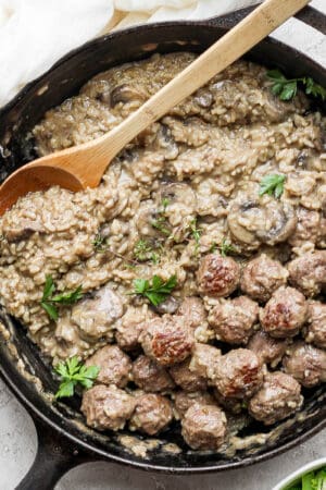 Skillet filled with creamy meatballs and rice.