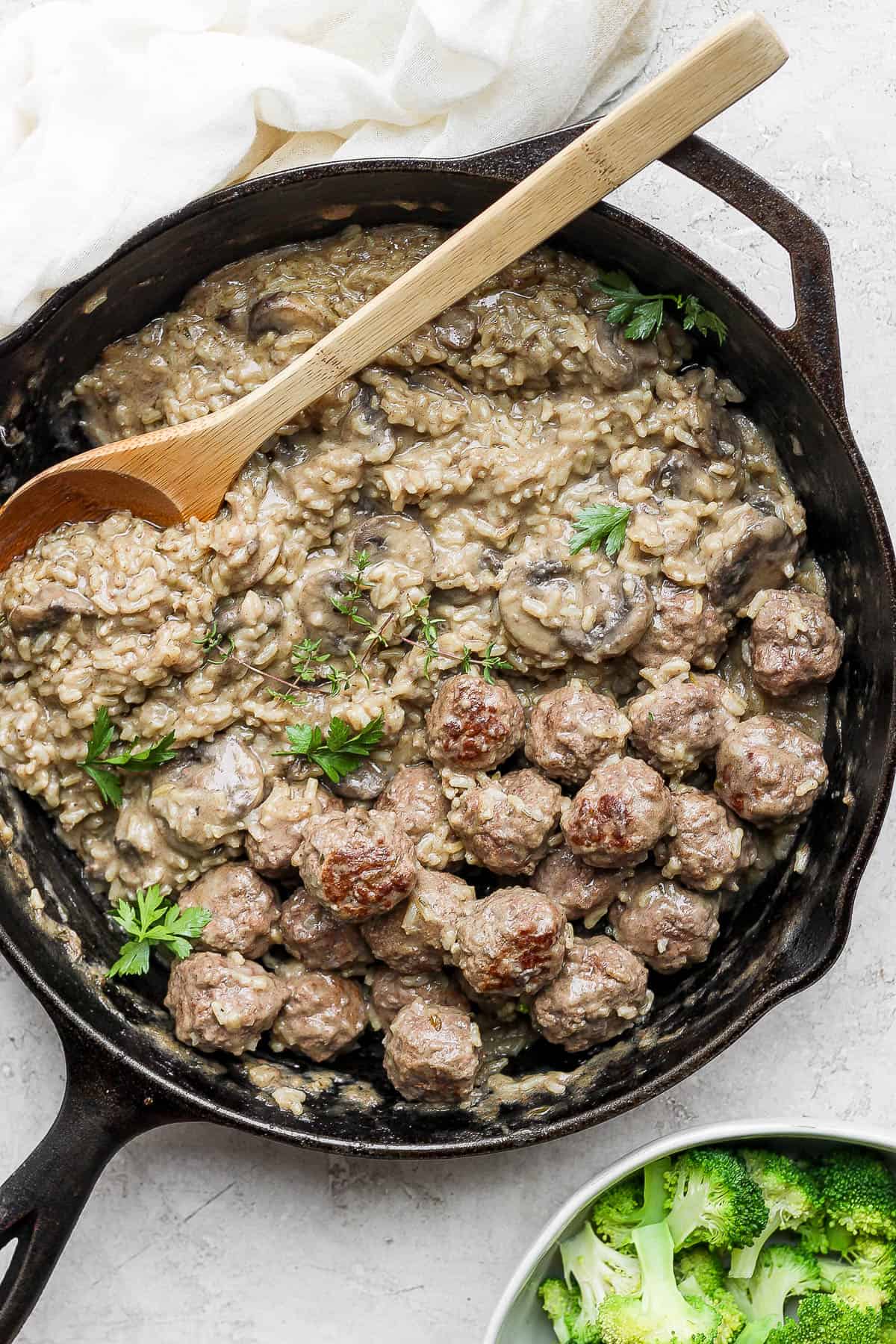 Meatballs and rice in a cast iron skillet.