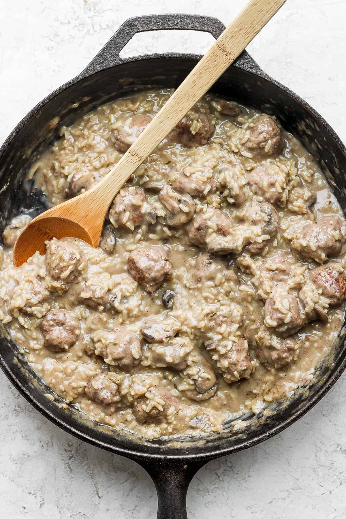Meatballs and rice in a cast iron skillet.