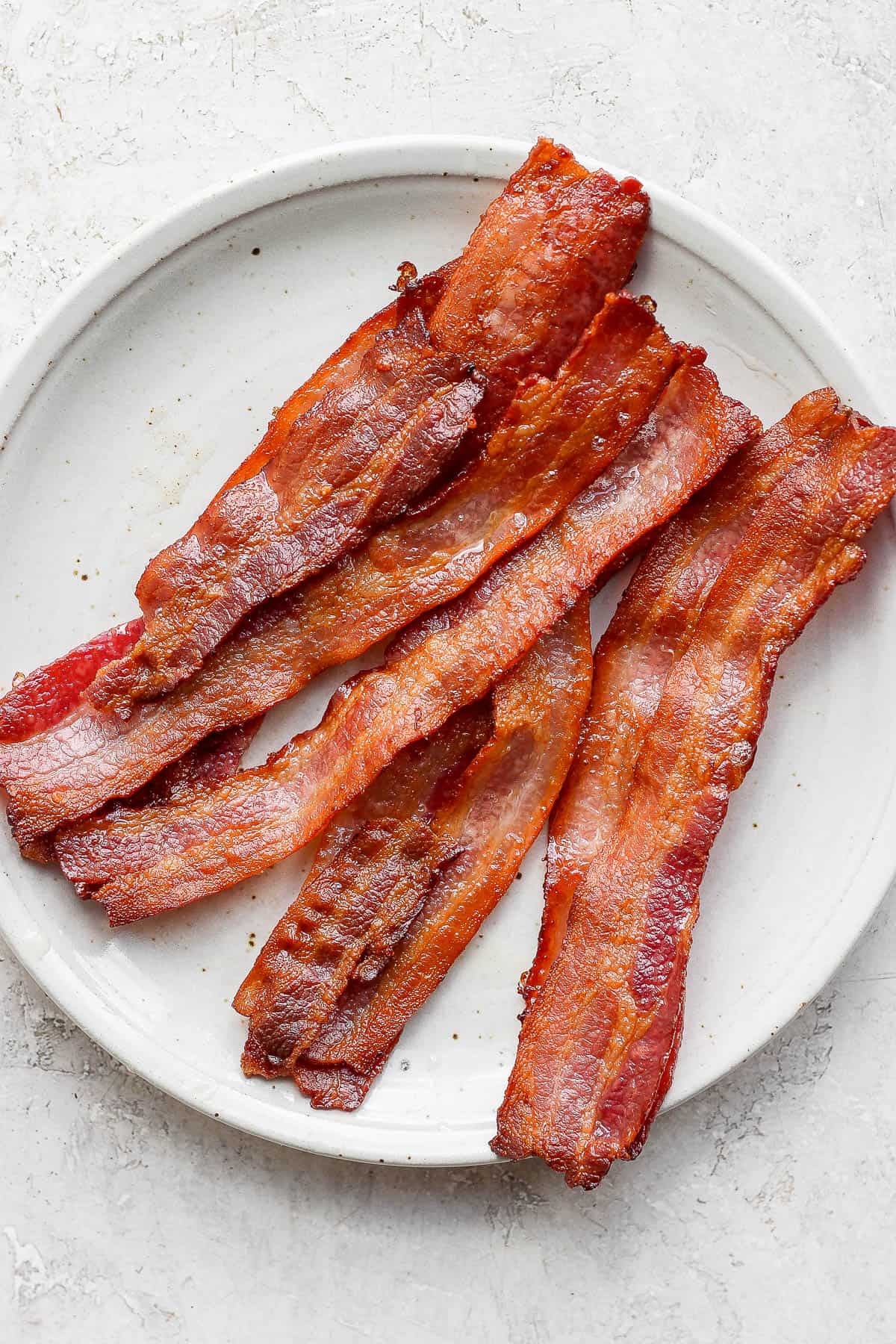 A plate of bacon after being baked in the oven.
