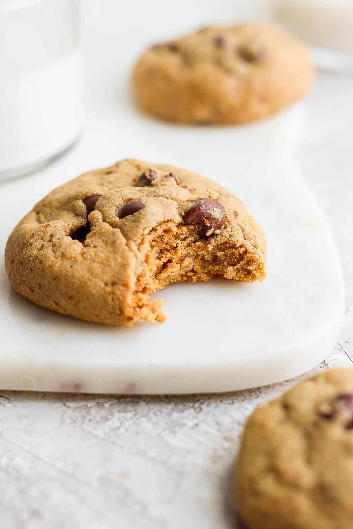 A paleo chocolate chip cookie with a bite taken out.