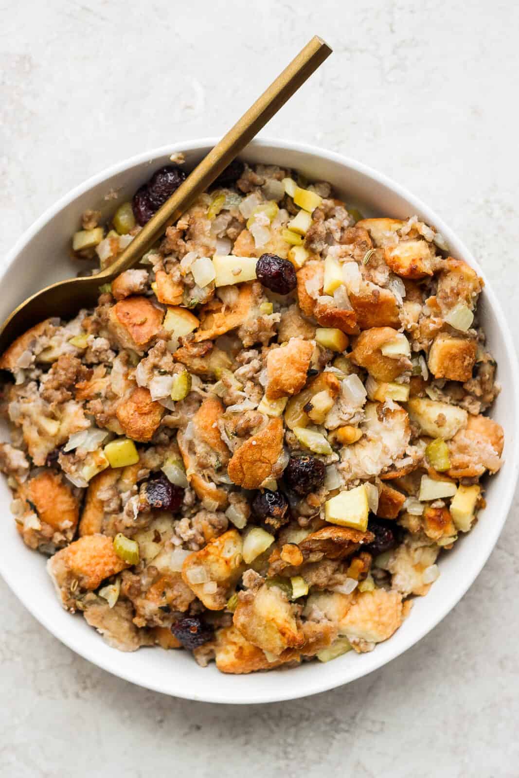 Bowl of sausage stuffing with a spoon.