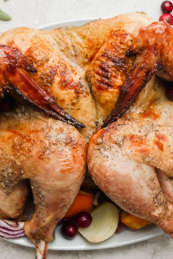 A smoked spatchcock turkey on a platter.