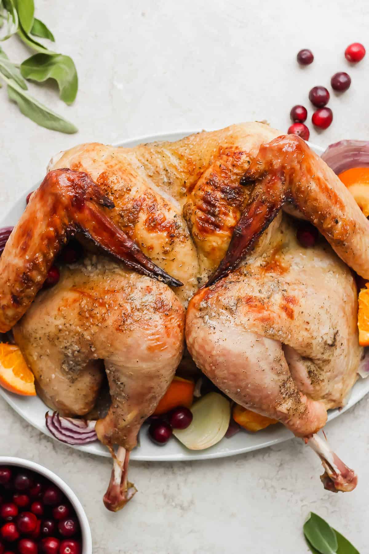 A smoked spatchcock turkey on a platter.