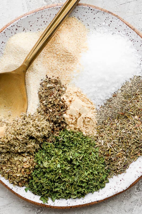 Smoked turkey dry rub ingredients separated on a small plate with a gold spoon.