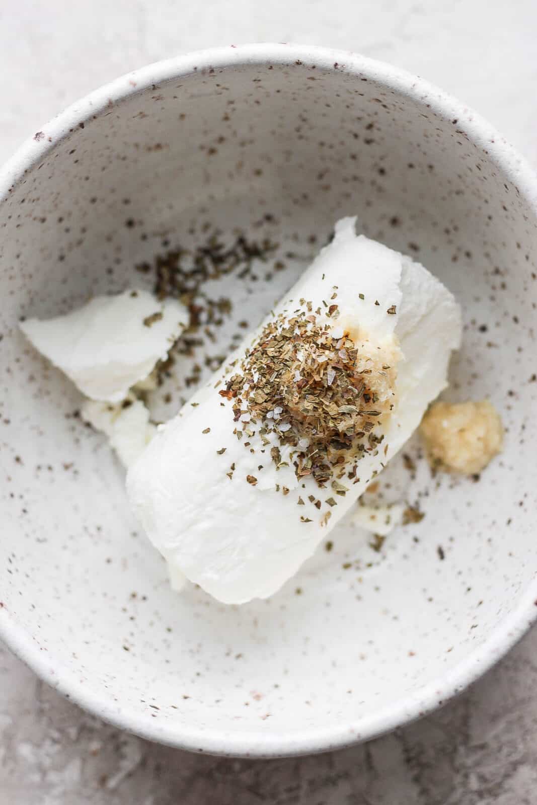 Goat cheese in a bowl with horseradish and herb. 