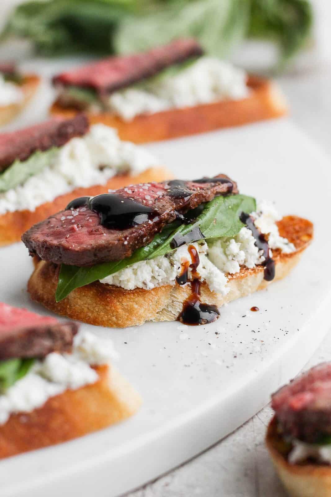 A steak crostini with goat cheese, basil and balsamic glaze. 