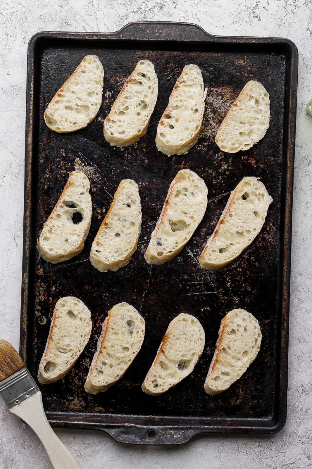 A small baking sheet with slices of baguette.