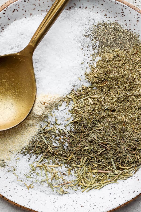 Turkey seasoning ingredients separated on a small plate with a gold spoon.