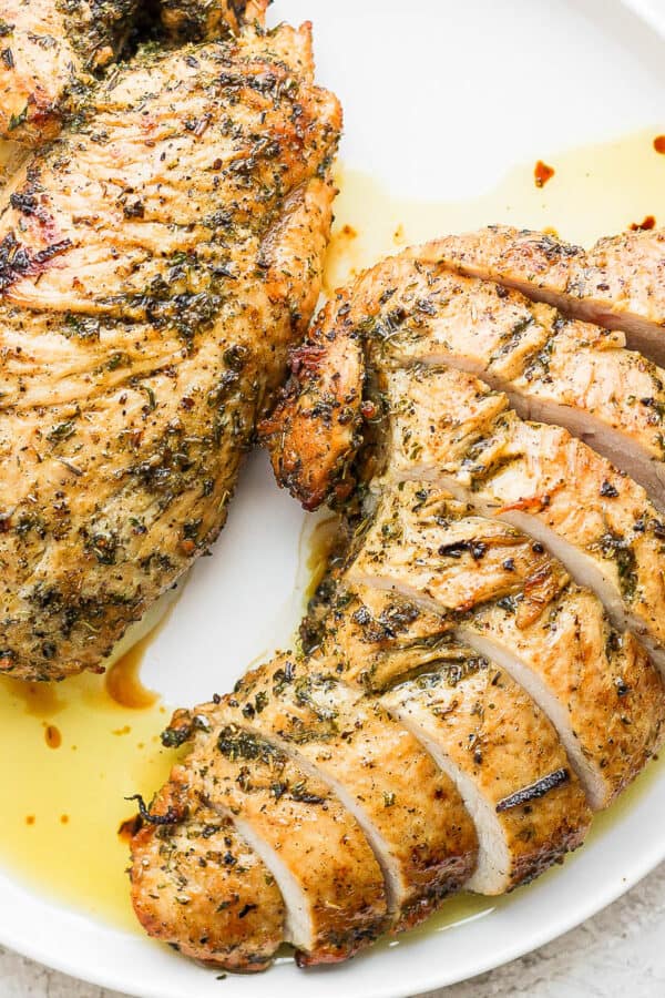 Plate with two turkey tenderloins, one is sliced.