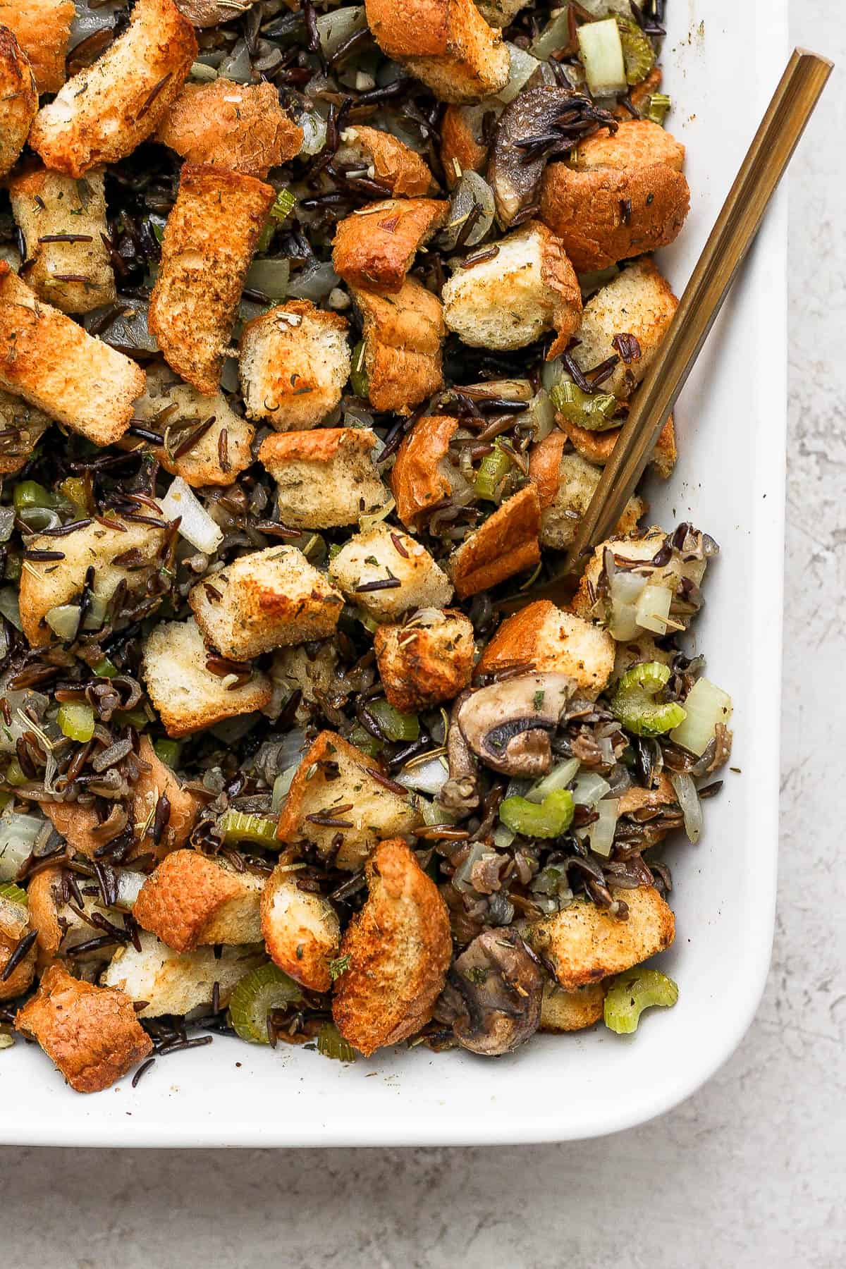 A spoon being scooped into wild rice stuffing.