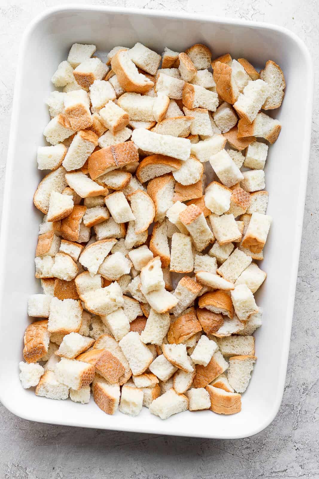 Dried bread cubes in a prepared baking dish.