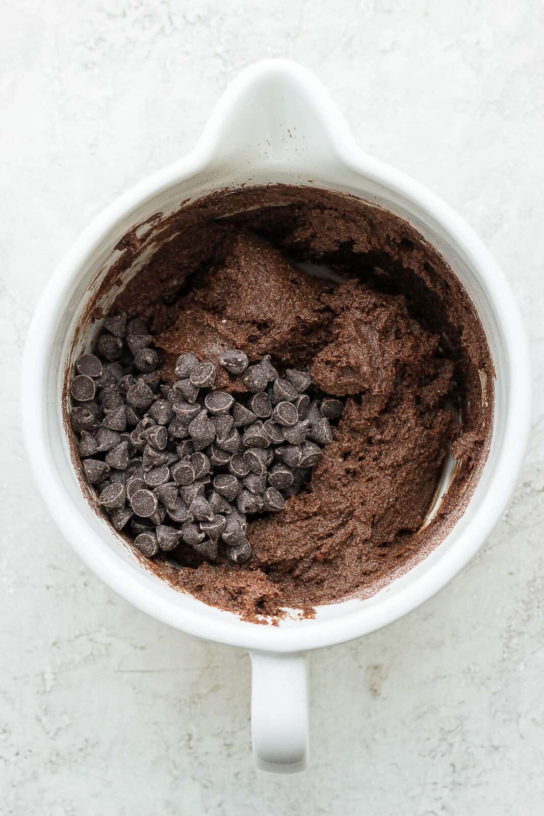 Batter for almond flour brownies in a bowl with chocolate chips on top. 