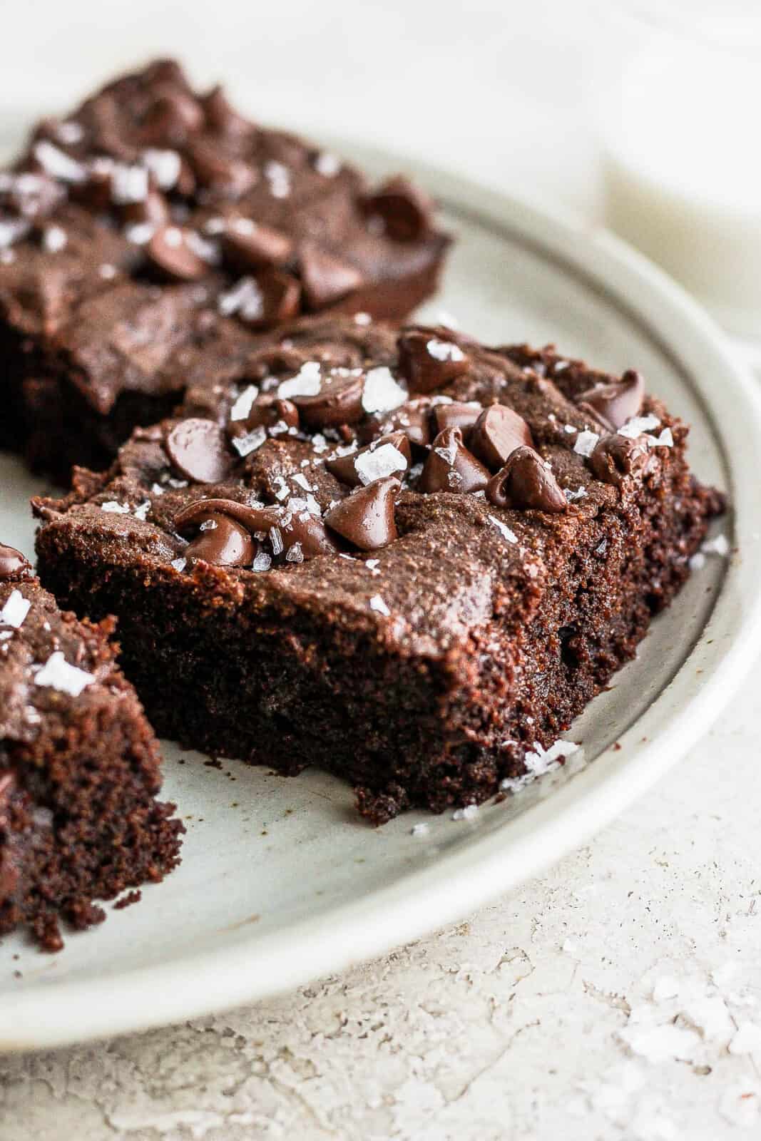 A side view of an almond flour brownie on a plate.