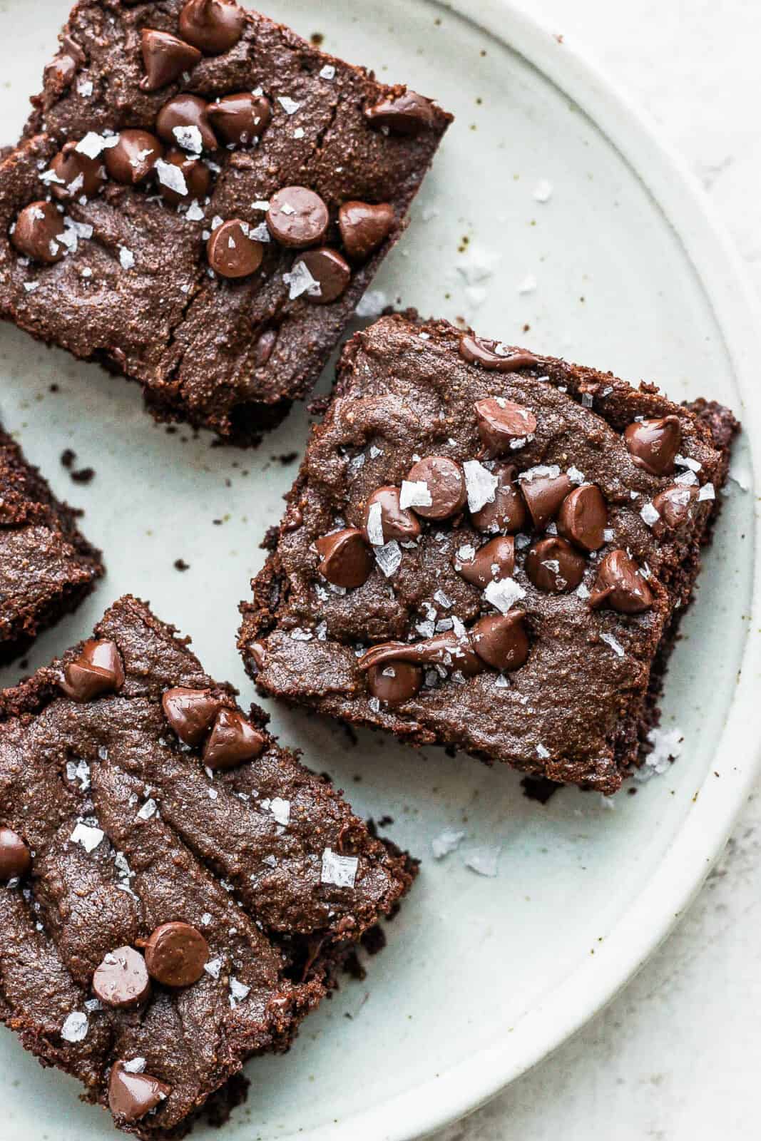 Three almond flour brownies on a plate.