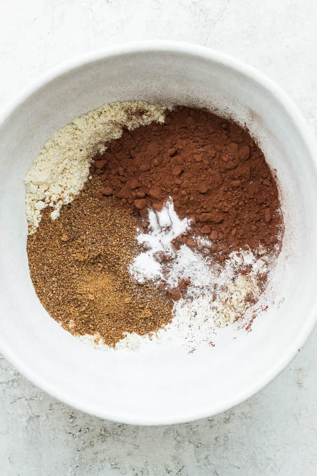 Almond flour, cocoa powder and coconut sugar in a bowl. 
