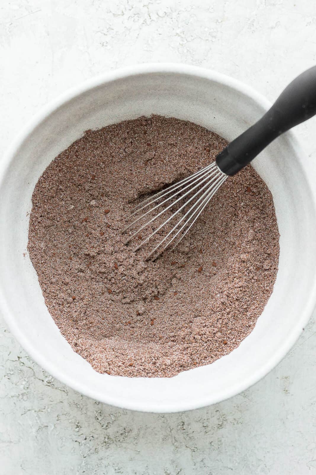 Almond flour, cocoa powder and coconut sugar in a bowl all mixed together.