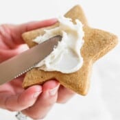 Someone frosting a sugar cookie with dairy free frosting.