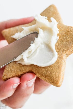 Someone frosting a sugar cookie with dairy free frosting.
